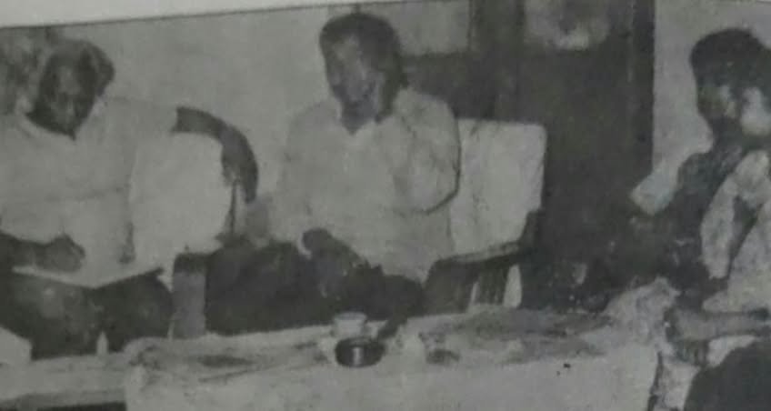 Grayscale group photograph of three people at a table